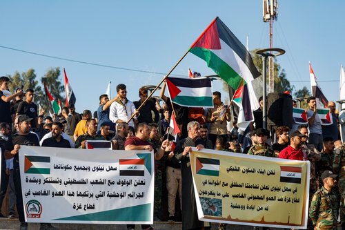 Supporters of Iraqi Shi'ite armed groups hold banners and flags at support of Palestinians in Gaza, in Mosul
