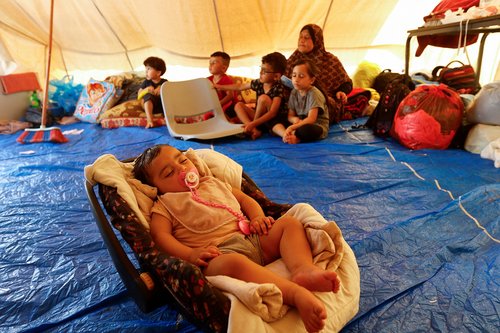Palestinians take shelter in a tent camp at a United Nations-run centre in Khan Younis