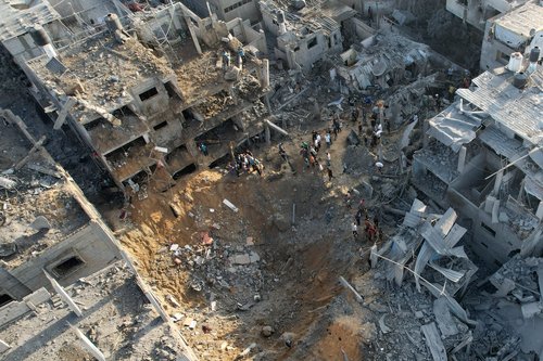 Palestinians gather at the site of Israeli strikes on houses, in Maghazi