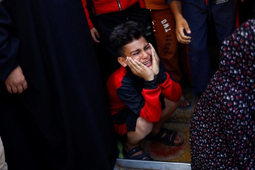 Palestinians react at a hospital, amid the ongoing conflict between Israel and Palestinian Islamist group Hamas, in Khan Younis