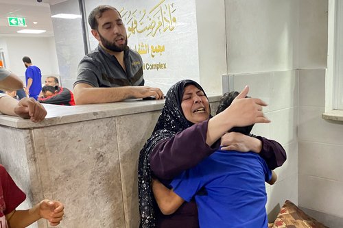 The mother of Palestinian Mohammed Abu Amira, who was killed in an Israeli strike, is comforted by her son