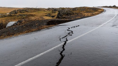 Cracks emerge on a road due to volcanic activity near a golf course, in Grindavik