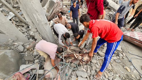 Palestinians search through the rubble at the site of Israeli strikes on houses in Jabalia refugee camp, in northern Gaza