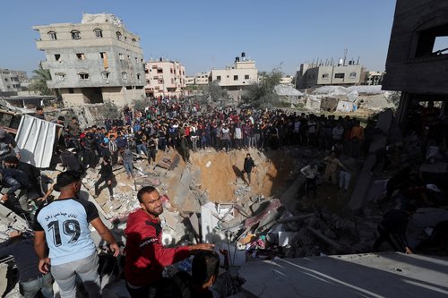 Palestinians gather as others search for casualties at the site of an Israeli strike on a house in Rafah, amid the ongoing conflict between Israel and the Palestinian Islamist group Hamas, in the southern Gaza Strip
