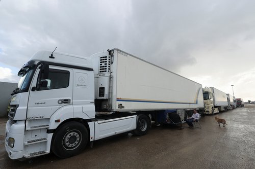 Trucks with humanitarian aid wait on the Egyptian side of the Rafah border crossing