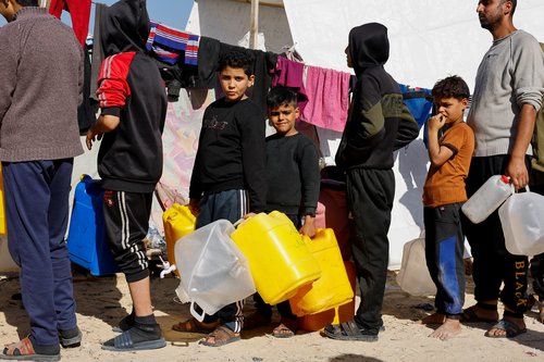 Displaced Palestinians, who fled their houses due to Israeli strikes, shelter in a tent camp near the border with Egypt, in Rafah