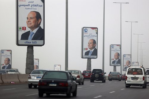Vehicles drive past posters of presidential candidate and current Egyptian President Abdel Fattah al-Sisi in Cairo