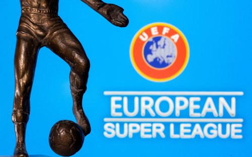 FILE PHOTO: A metal figure of a football player with a ball is seen in front of the words "European Super League" and the UEFA logo in this illustration