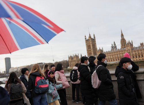 Tourists walk by Westminster Bridge in London