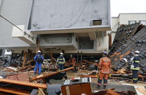 Rescue workers conduct resuce operations at a collapsed building caused by an earthquake in Wajima