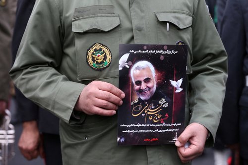 FILE PHOTO: Iranian policeman man holds a picture of late General Qassem Soleimani in Tehran