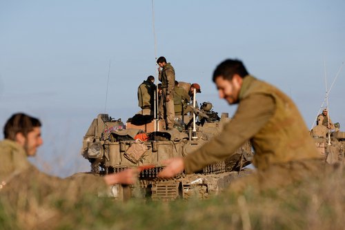 Israeli soldier stands on military vehicle on the way out of Gaza Strip, as seen from southern Israel