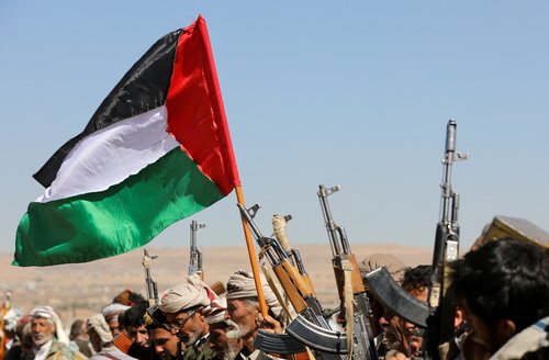 FILE PHOTO: Tribal supporters of Yemen's Houthis wave a Palestinian flag and hold up their firearms during a protest on recent U.S.-led strikes on Houthi targets, near Sanaa