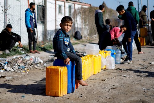 FILE PHOTO: Displaced Palestinians, who fled their houses due to Israeli strikes, shelter at a tent camp in Rafah