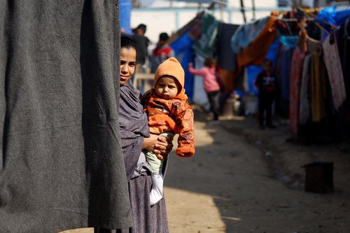 Displaced Palestinians, who fled their houses due to Israeli strikes, shelter at a tent camp in Rafah
