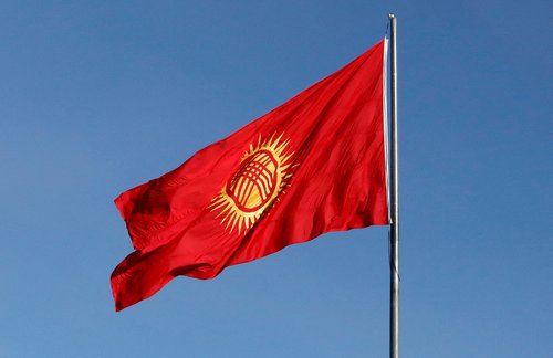 FILE PHOTO: Honour guards march near the renewed Kyrgyz national flag during a ceremony in Bishkek
