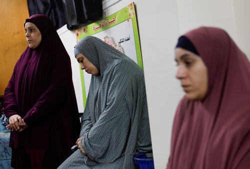 Palestinian women who were detained by Israel take refuge at a school after their release, in Rafah