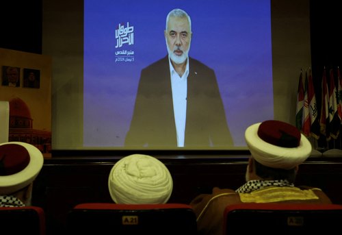 Hamas chief Ismail Haniyeh speaks in a pre-recorded message shown on a screen during an event ahead of al-Quds, in Beirut