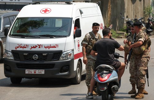 A Lebanese Red Cross vehicle drives by Lebanese army soldiers near the U.S. embassy in Awkar