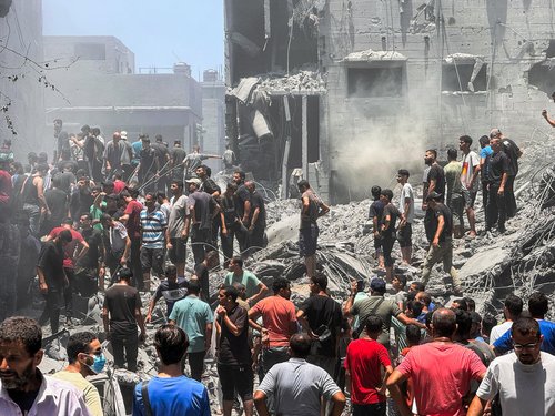 Palestinians search for casualties at the site of Israeli strikes on houses