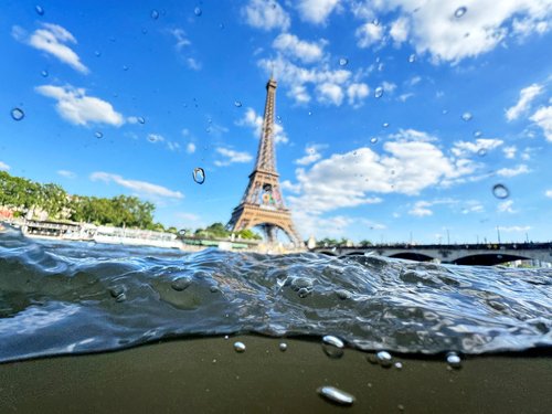 The Eiffel Tower is seen from the water of the Seine River as the Olympics opening ceremony rehearsal is postponed amid rainy weather.