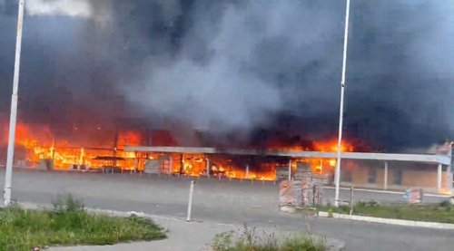 Smoke and flames rise from a shopping center damaged by shelling, in Donetsk
