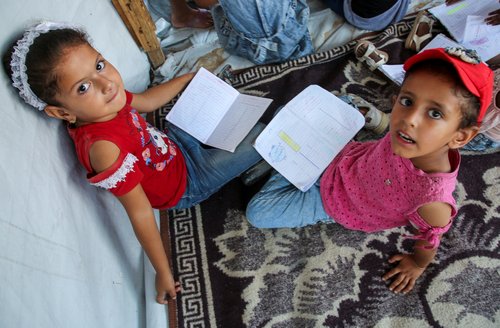Gaza teacher welcomes students in a classroom tent set up on the rubble of her house