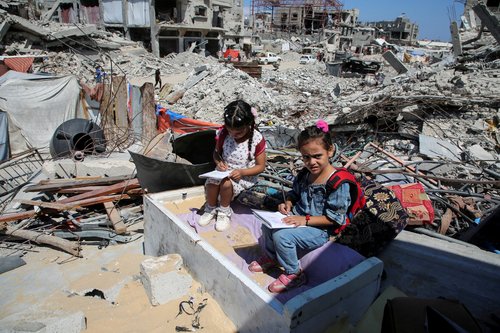 Gaza teacher welcomes students in a classroom tent set up on the rubble of her house