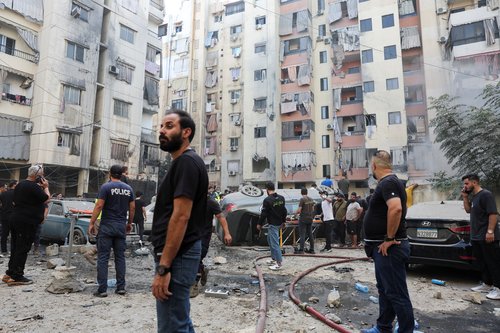 People inspect the site of an Israeli strike, in Beirut