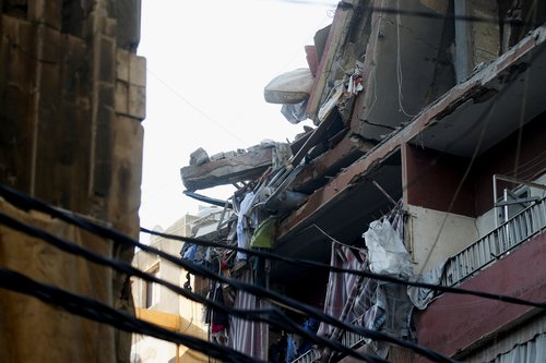 People gather at the site of an Israeli strike in Beirut's southern suburbs