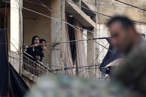 People gather at the site of an Israeli strike in Beirut's southern suburbs
