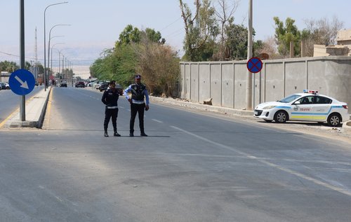Police members man a checkpoint near King Hussein Bridge crossing