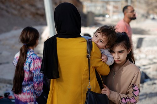 People cross from Lebanon into Syria on foot at the Masnaa border crossing,after Israeli strikes earlier this month