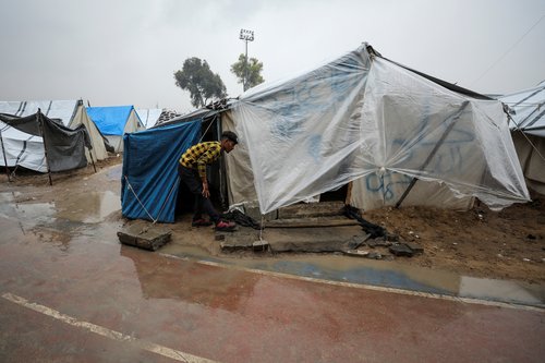 Displaced Palestinians fix their tents following rainfall, in Gaza City