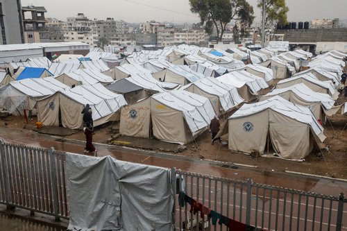 Displaced Palestinians fix their tents following rainfall, in Gaza City
