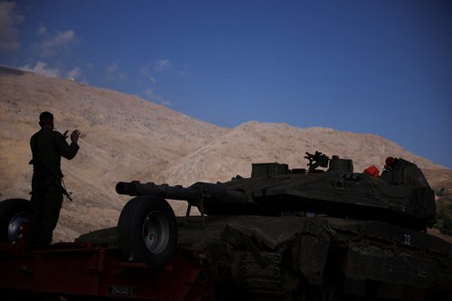 Israeli military gather near the ceasefire line between Syria and the Israeli-occupied Golan Heights
