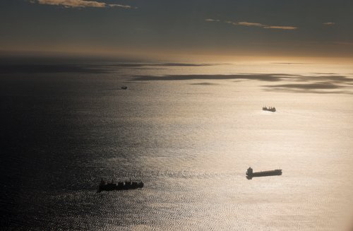 An aerial view shows cargo and tankers ships sailing in the Mediterranean sea in front of the port in Barcelona