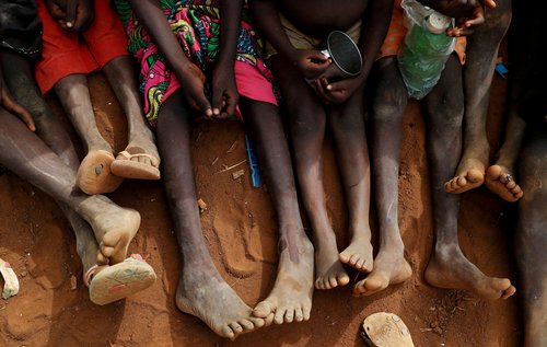 FILE PHOTO: Internally displaced orphans from Kadugli gather to eat boiled leaves at an IDP camp in South Kordofan, Sudan
