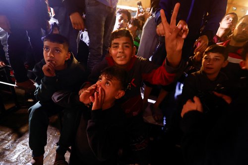 Palestinians react as they wait for news of a ceasefire deal with Israel, in Khan Younis in the southern Gaza Strip