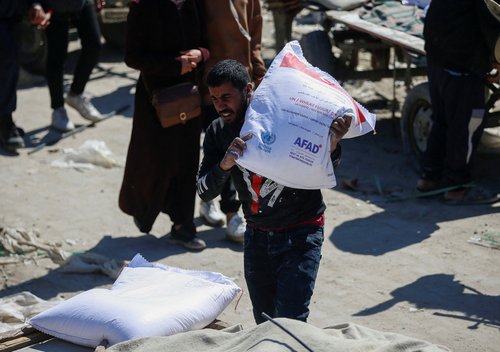 Palestinians gather to receive aid, at Jabalia refugee camp in northern Gaza Strip