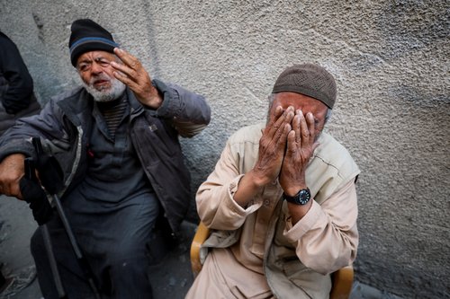 Palestinians inspect the site of an Israeli strike on a residential building in Jabalia