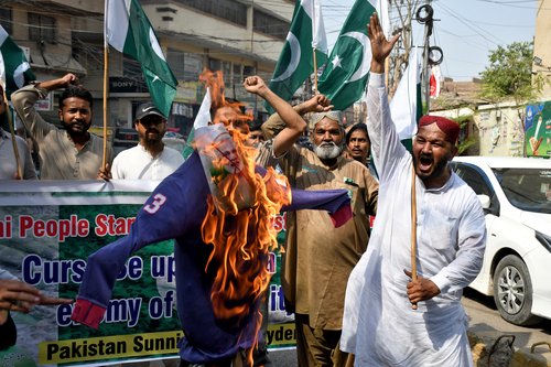 Demonstrators shout slogans as they burn an effigy during an anti-India protest following India's military strikes on Pakistan