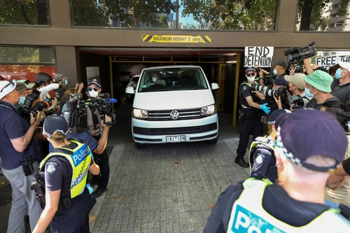 Media surround a vehicle at the facility where Novak Djokovic has been held in Melbourne