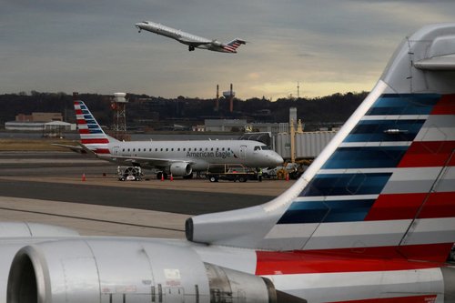 FILE PHOTO: A jet from American Eagle, a regional branch of American Airlines (AA), takes off past other AA aircraft at Ronald Reagan Washington National Airport in Arlington