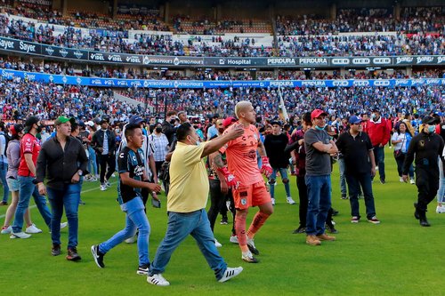 Soccer players and people walk on the field at the Corregidora stadium in Queretaro