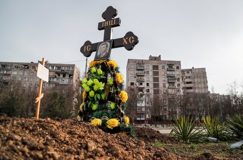 Graves of civilians killed during Ukraine-Russia conflict are seen next to apartment buildings in the southern port city of Mariupol