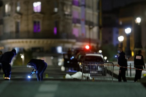 French police forensic officers inspect the scene of a shooting on the Pont Neuf bridge, in Paris