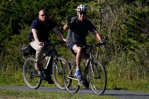 U.S. President Joe Biden rides a bike in Rehoboth Beach, Delaware