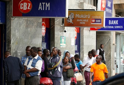 FILE PHOTO: Zimbabweans queue outside a bank in Harare