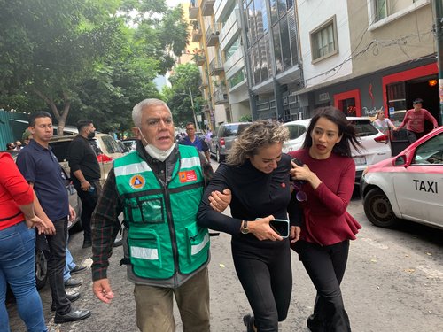 People wait outside their homes after a quake, in Mexico City